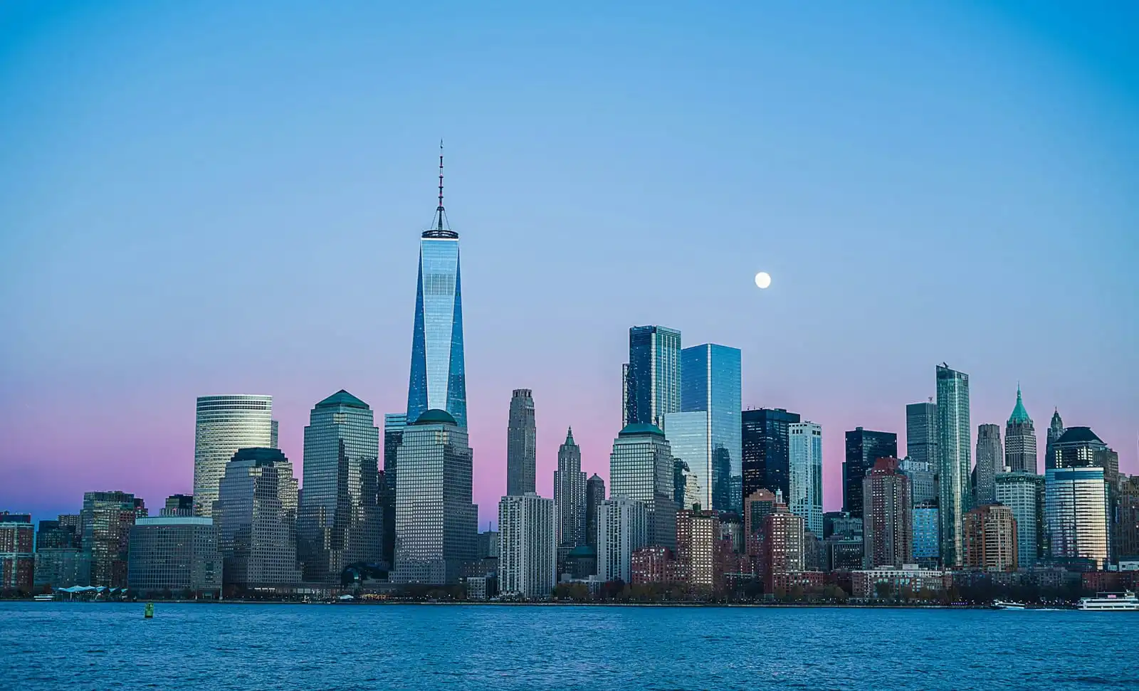 The Lower Manhattan skyline at dusk, seen across the water
